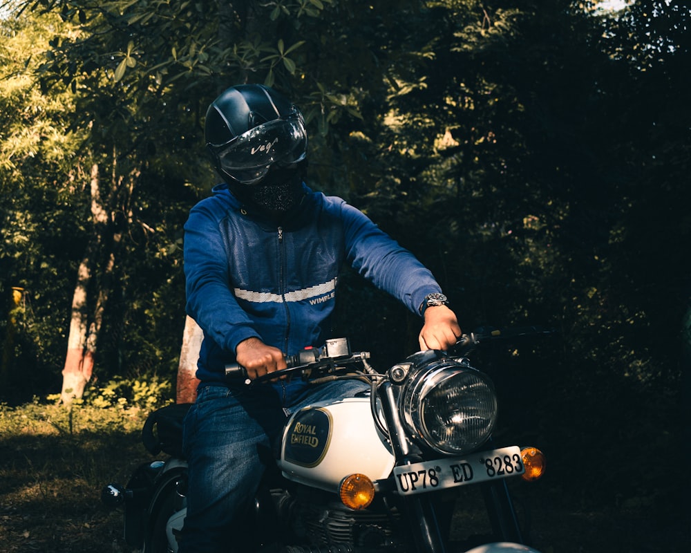 man in blue jacket riding motorcycle