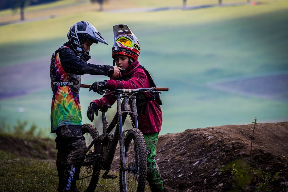 uomo in giacca nera in sella a mountain bike nera e rossa