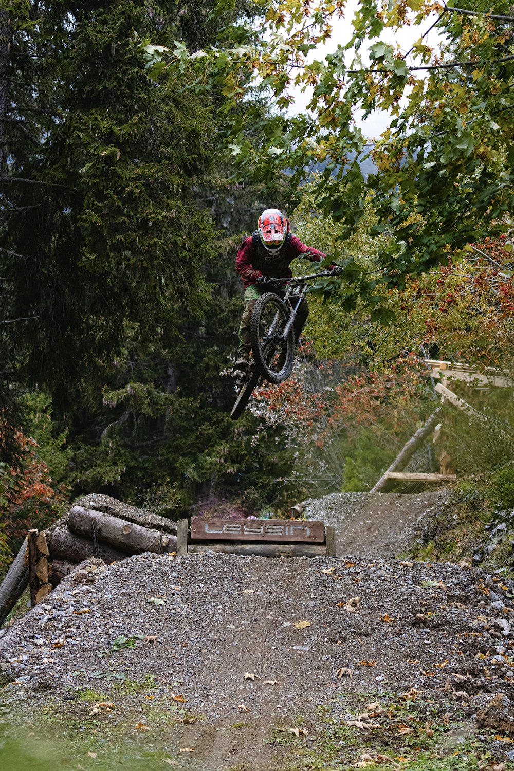 man in red jacket riding mountain bike