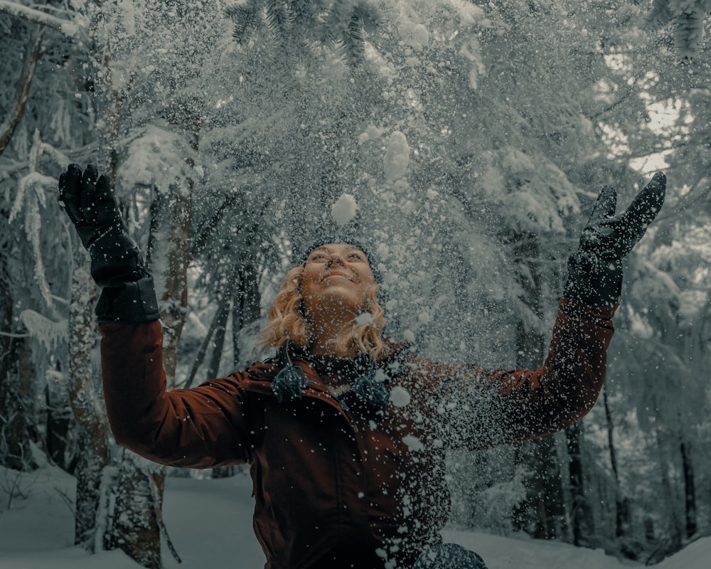 Frau in schwarzer Jacke weht Schnee