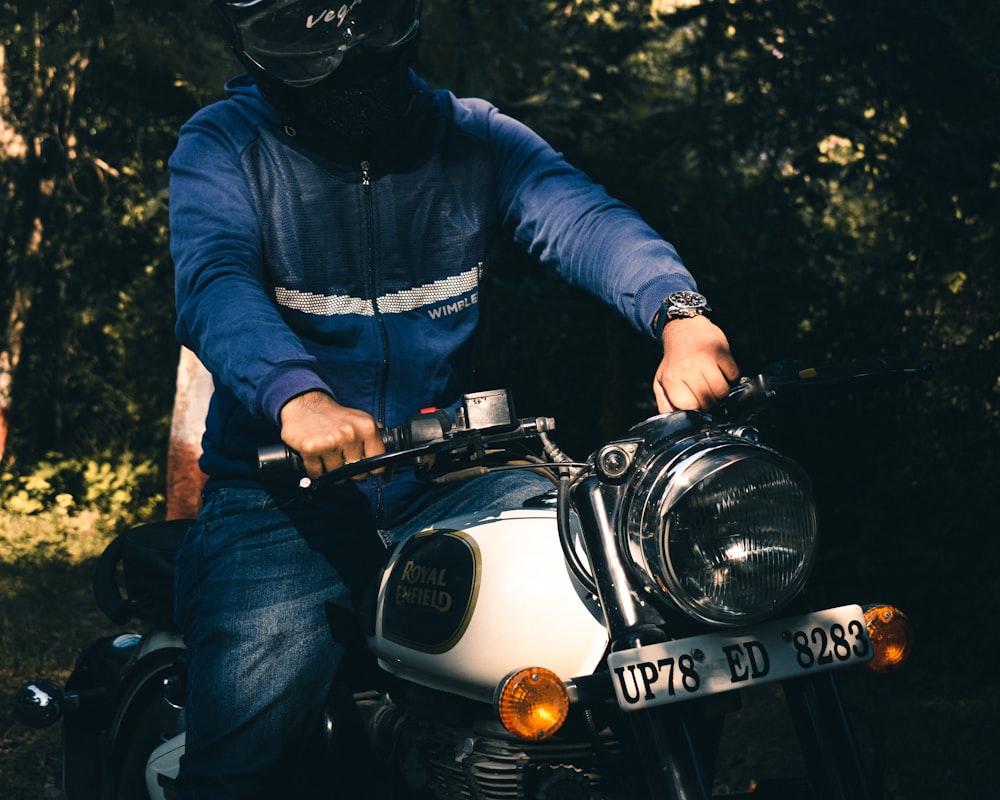 man in blue jacket riding on motorcycle