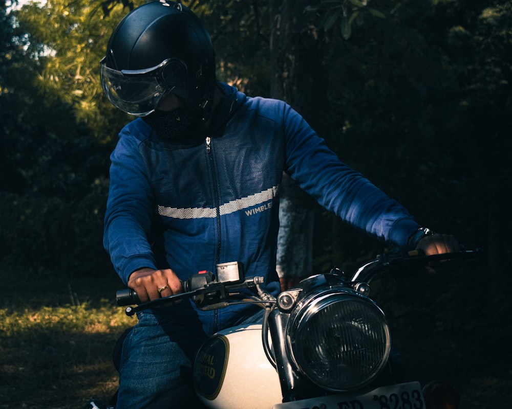 man in blue jacket riding motorcycle