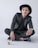man in black blazer and black pants wearing black hat sitting on floor