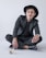man in black blazer and black pants wearing black hat sitting on floor