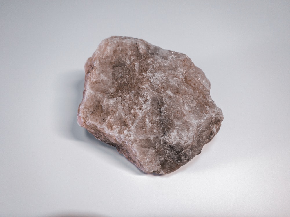 Piedra marrón y gris sobre superficie blanca