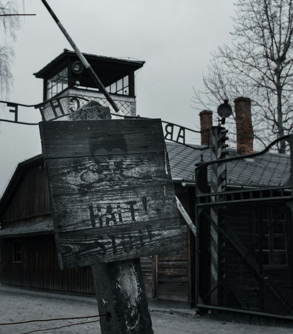 schwarze Holzbeschilderung auf braunem Holzpfosten