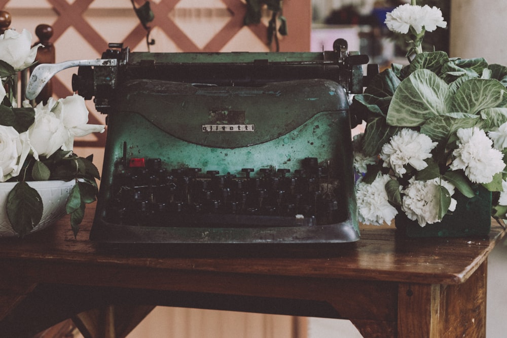máquina de escrever preta na mesa de madeira marrom