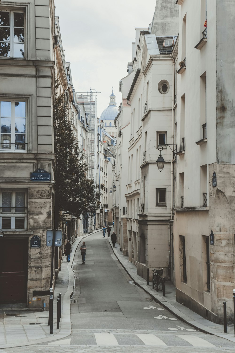 cars parked beside the road in between buildings during daytime