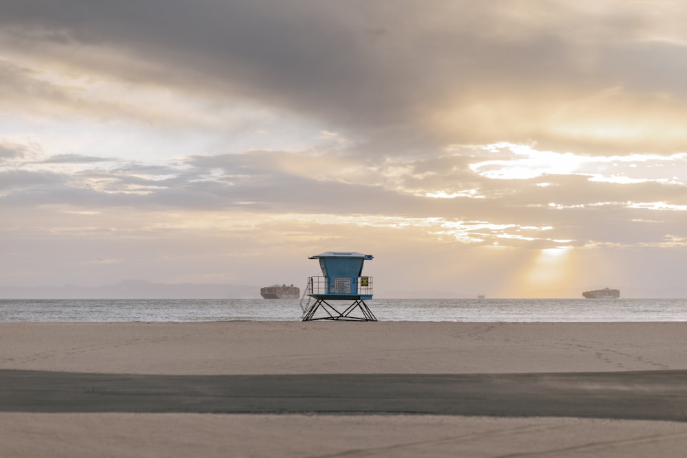 blue lifeguard house on beach during sunset