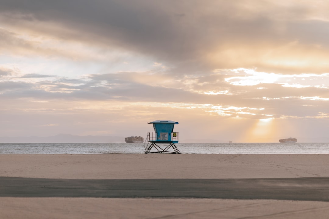 blue lifeguard house on beach during sunset