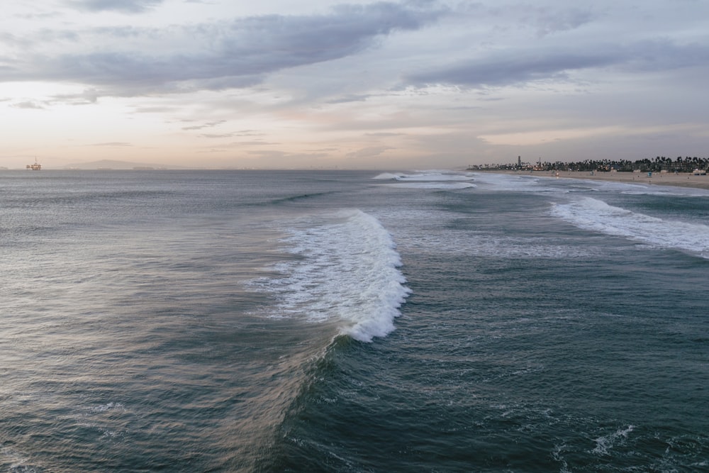 ocean waves crashing on shore during daytime