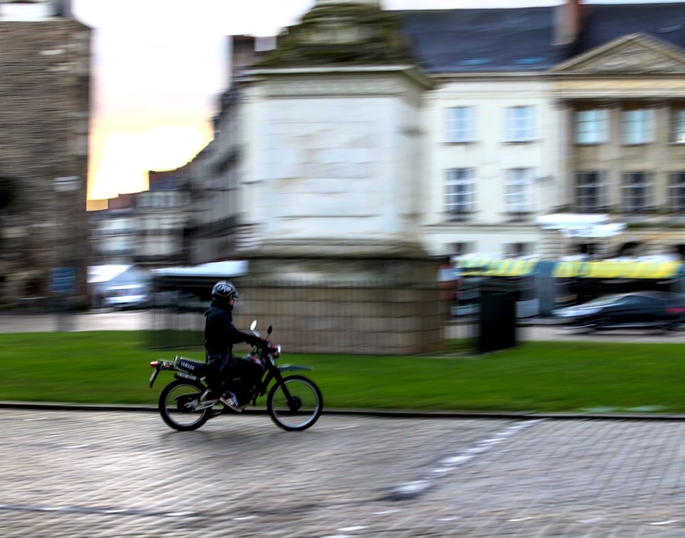 man in black shirt riding on black bicycle on road during daytime