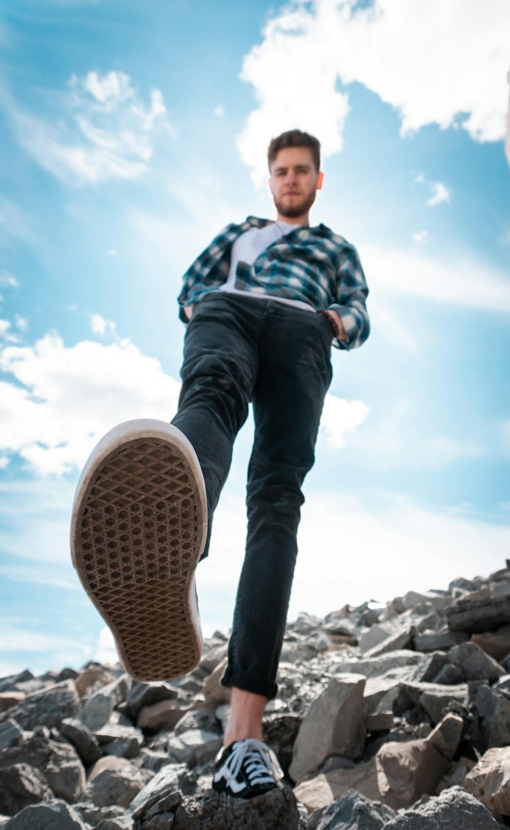 boy in blue white and red plaid dress shirt and blue denim jeans standing on rocky