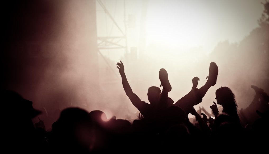 silhouette of people raising their hands