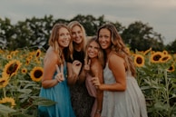 A diverse group of women smiling and embracing in a sunlit garden, radiating support and joy.