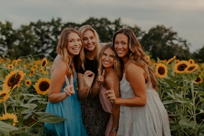 A warm group photo of diverse Christian girls smiling and holding hands in a sunlit garden.