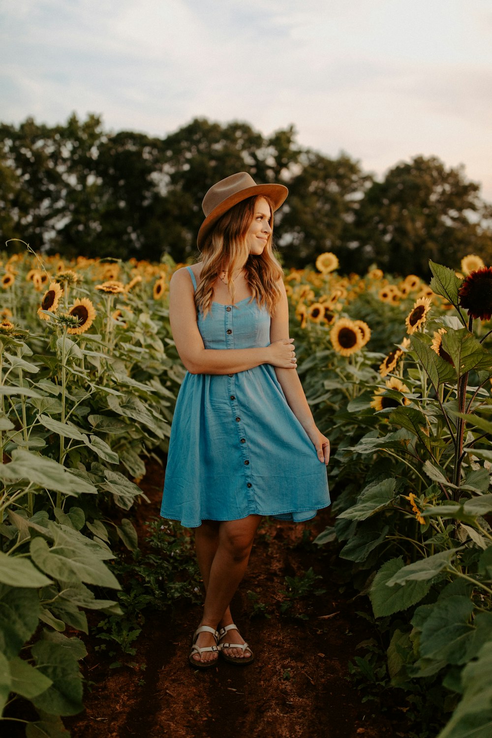 woman in blue dress standing on green grass field during daytime