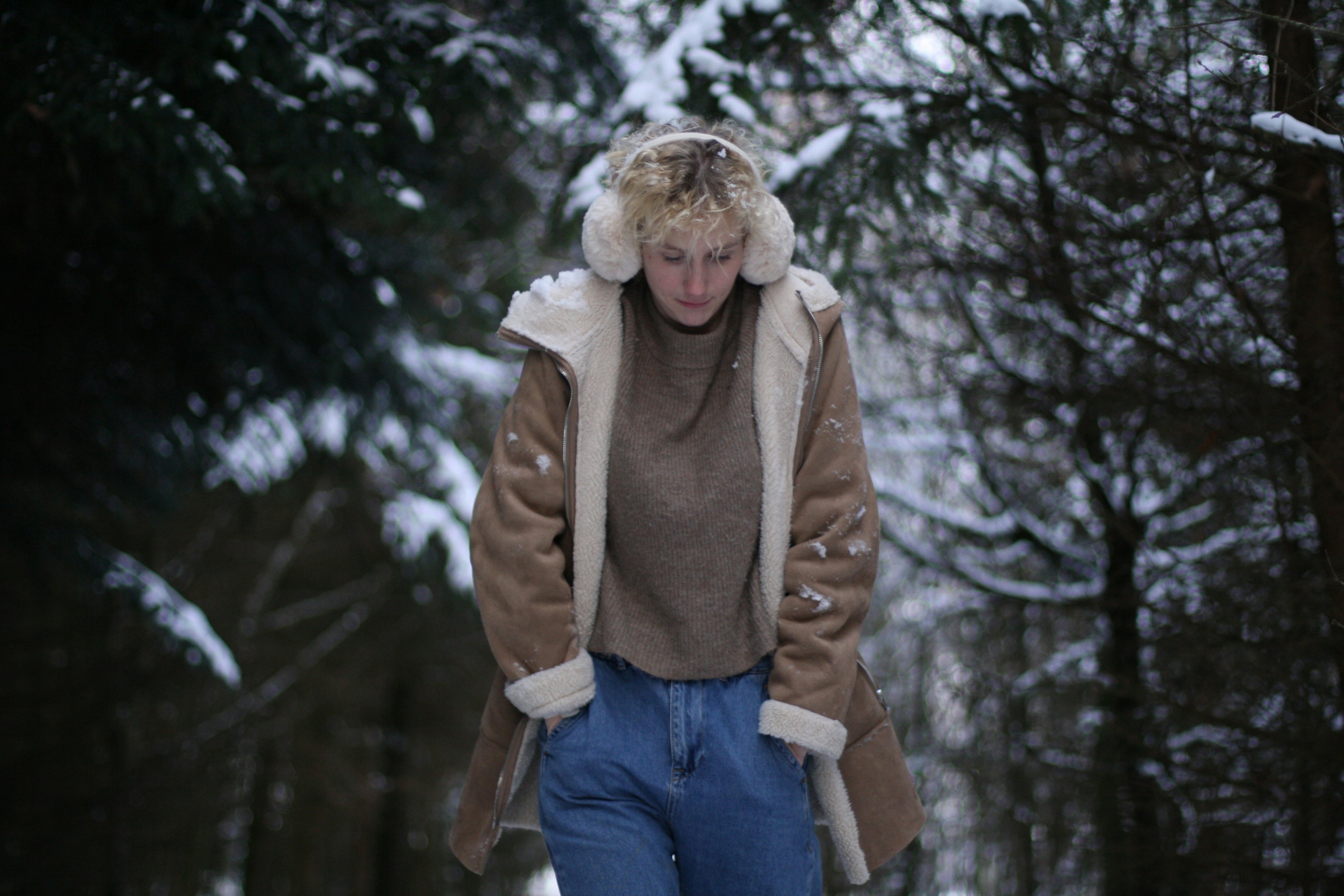 겨울철 플리스 조거팬츠 스타일링 - woman in brown jacket and blue denim jeans standing on snow covered ground during daytime