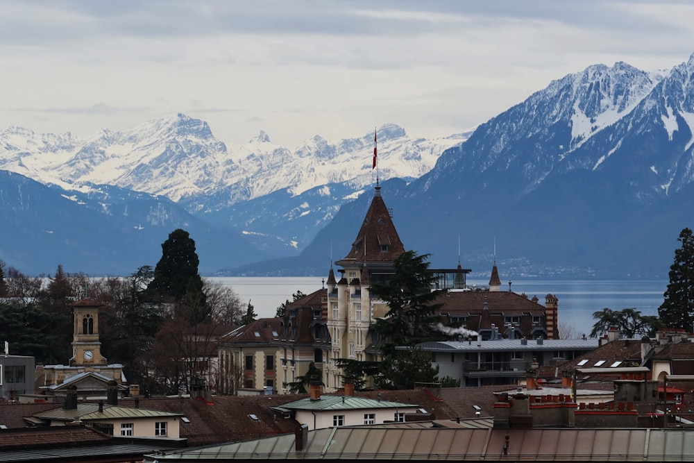 white and brown concrete building near snow covered mountain during daytime