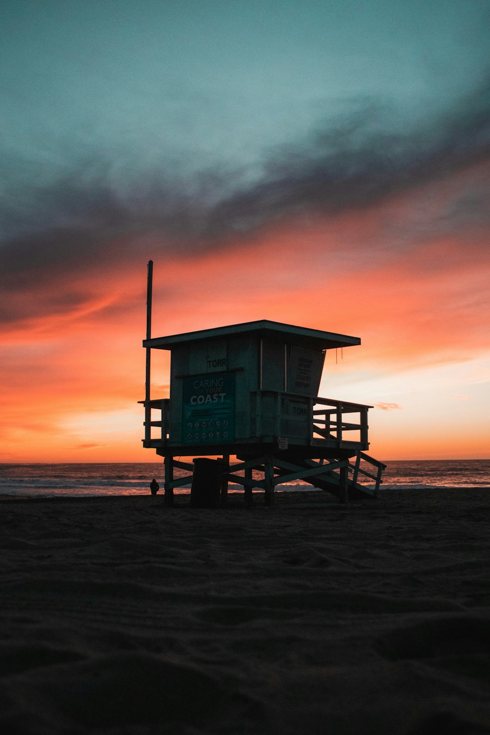 white wooden lifeguard house on beach during sunset