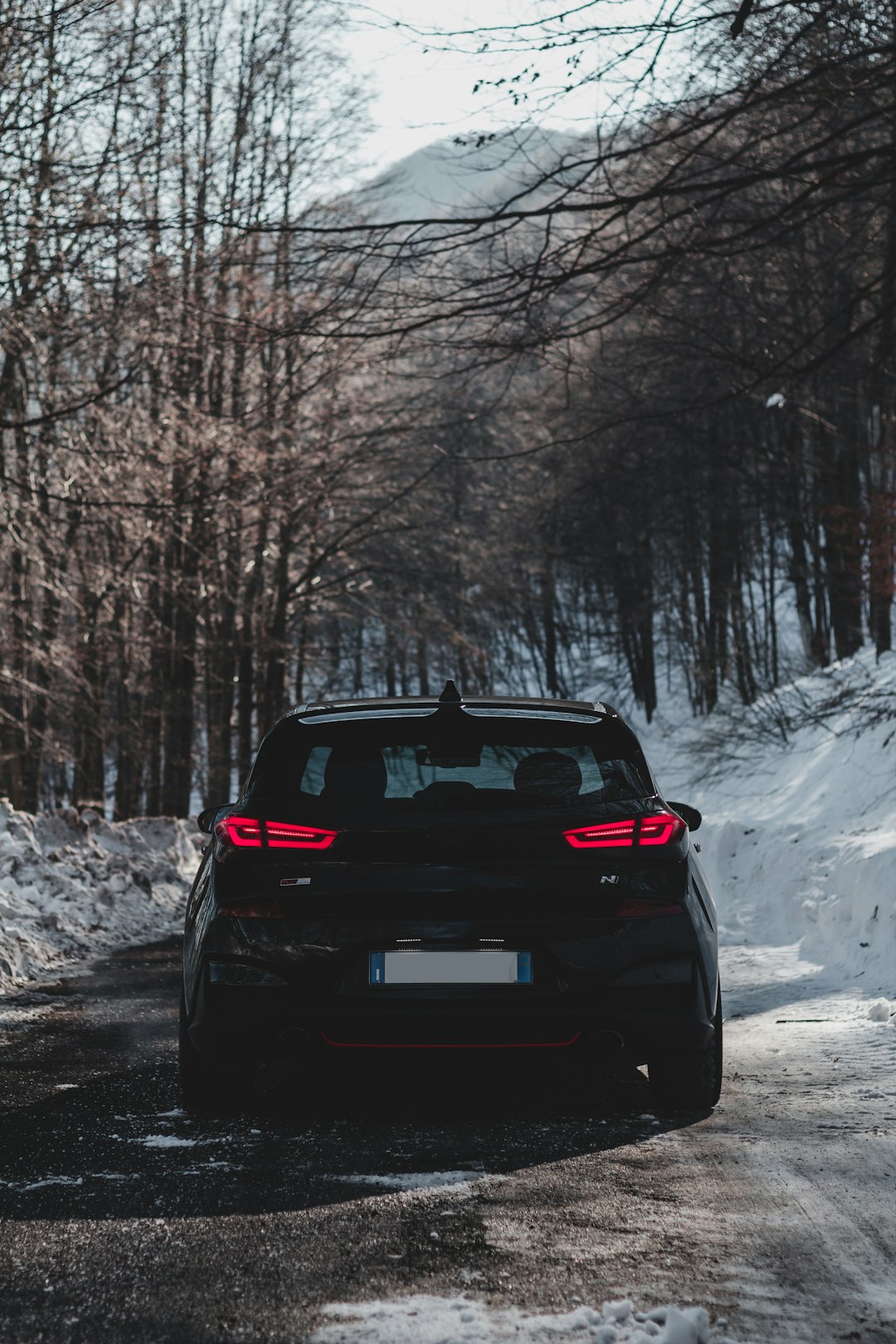 black car on snow covered ground during daytime