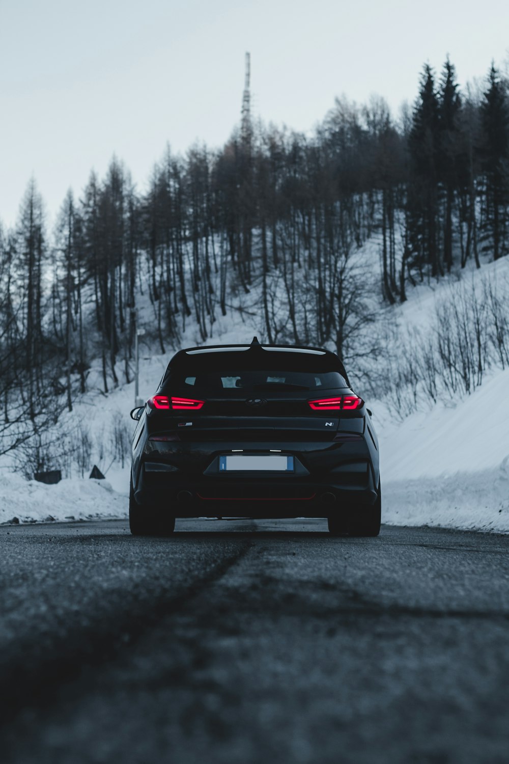 black bmw car on snow covered road during daytime