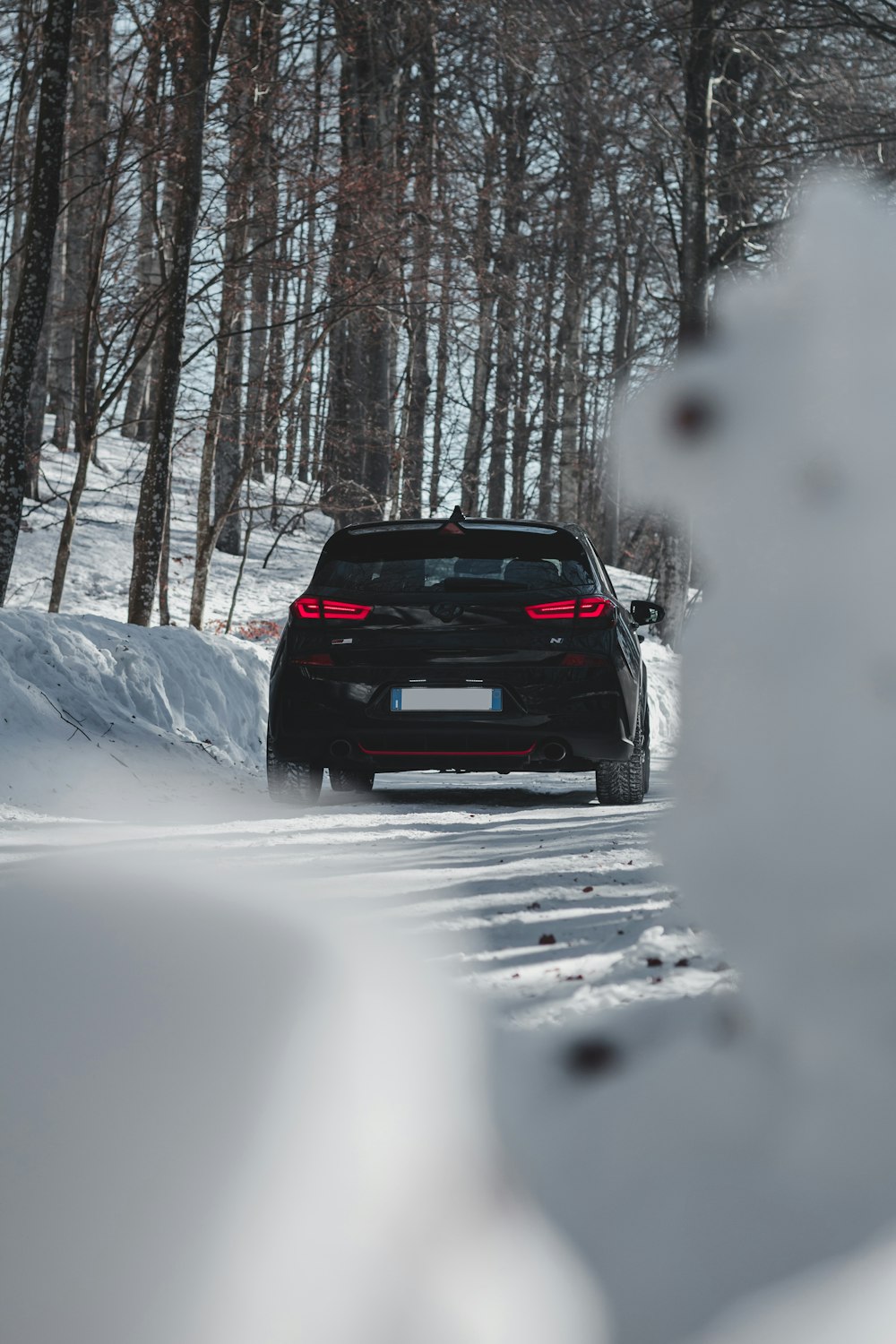 black car on snow covered road during daytime