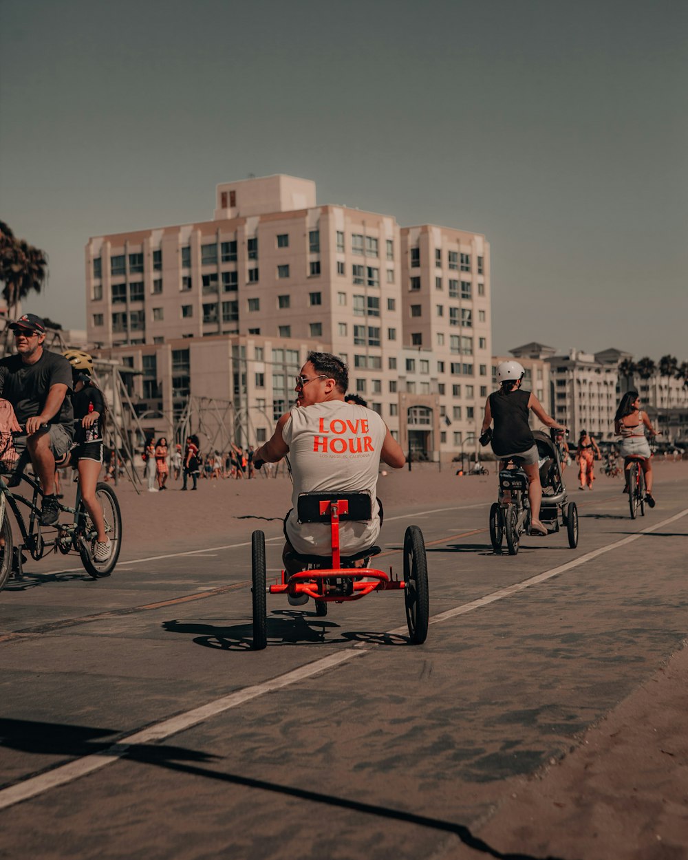 man in white t-shirt riding on black and red bicycle during daytime