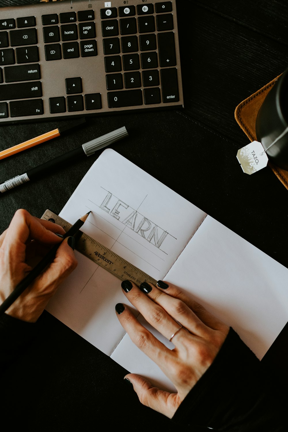 personne écrivant sur du papier blanc