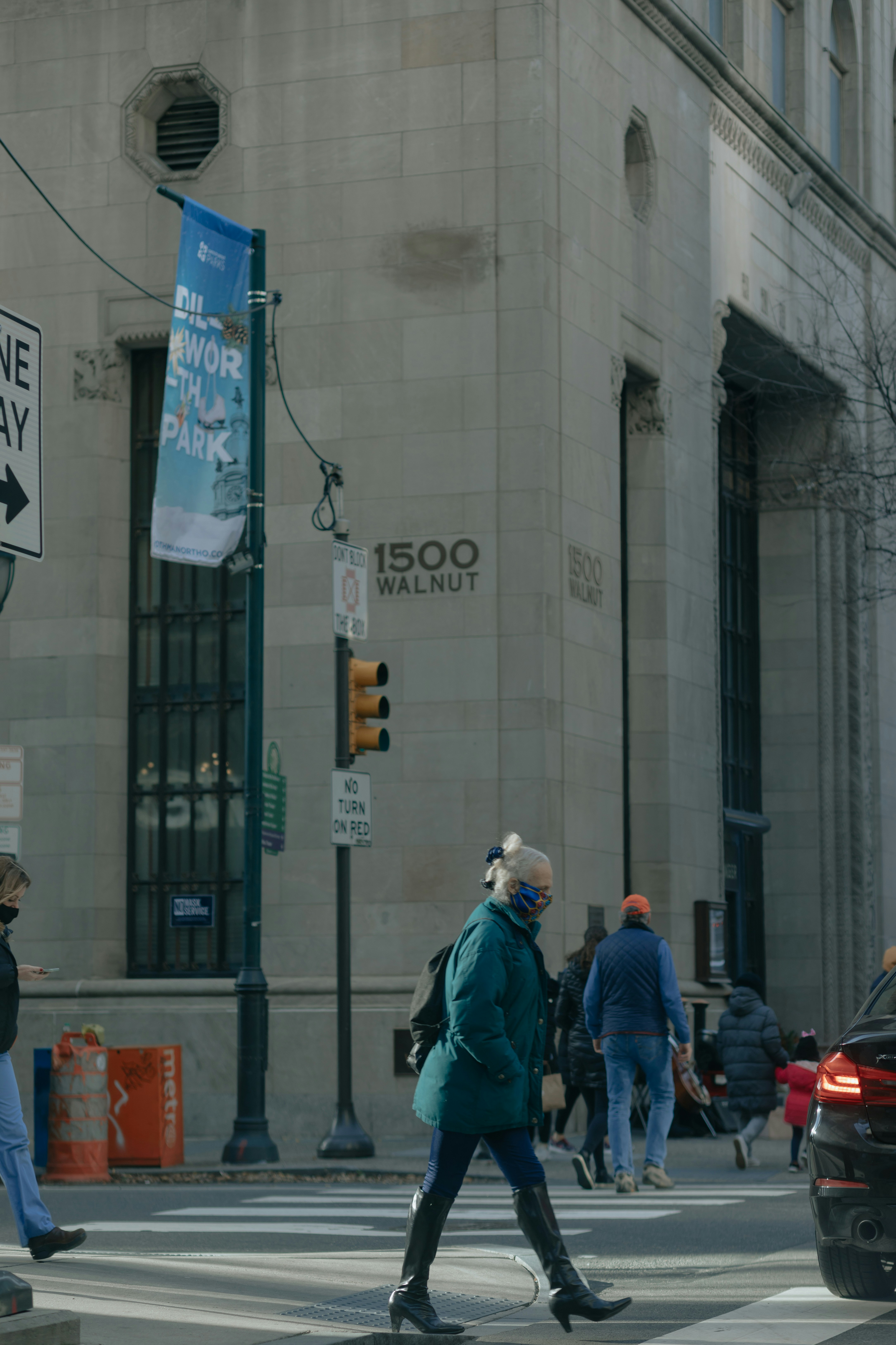 man in blue jacket walking on street during daytime