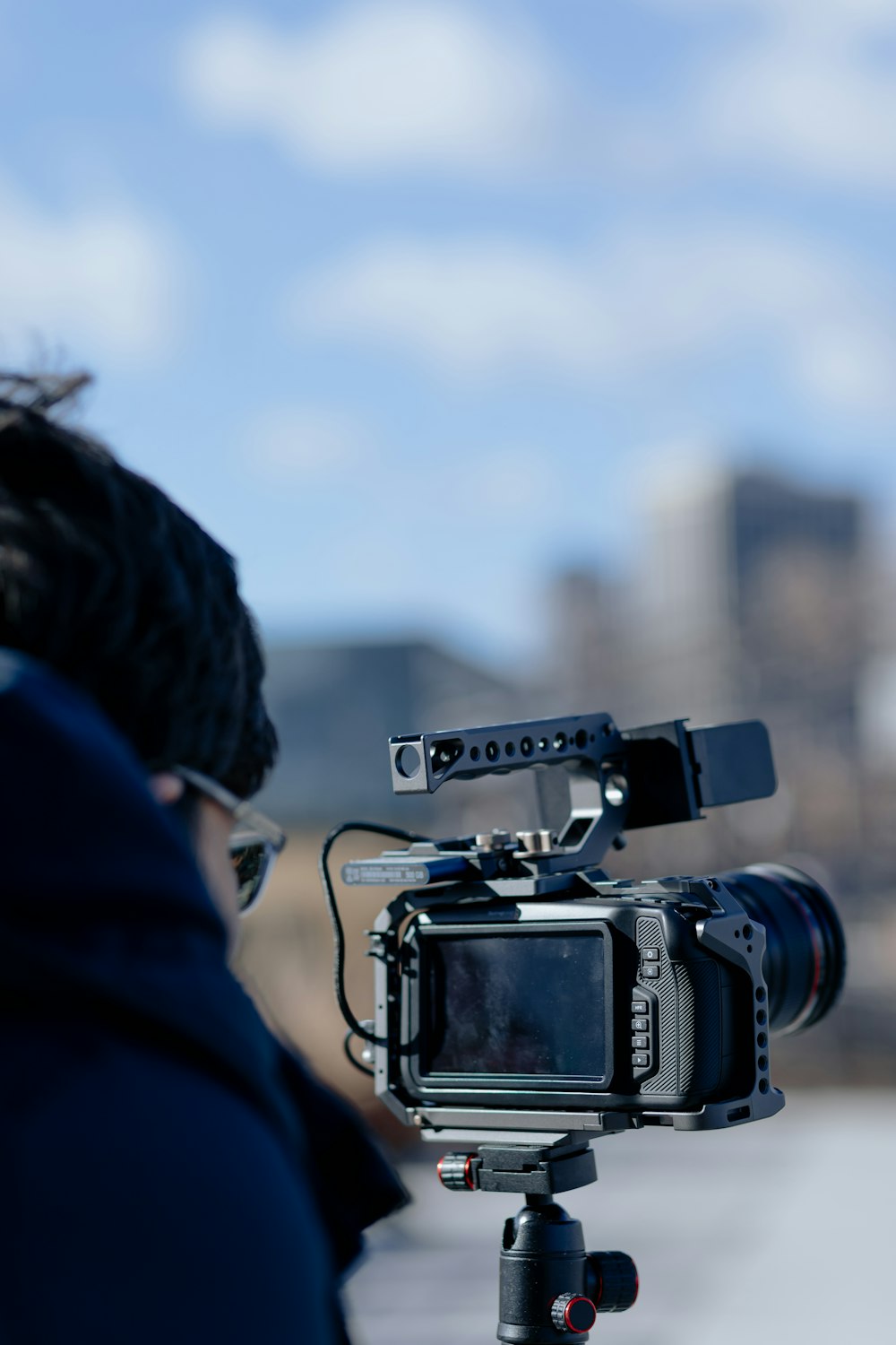 Persona con chaqueta azul tomando foto de la cámara DSLR negra