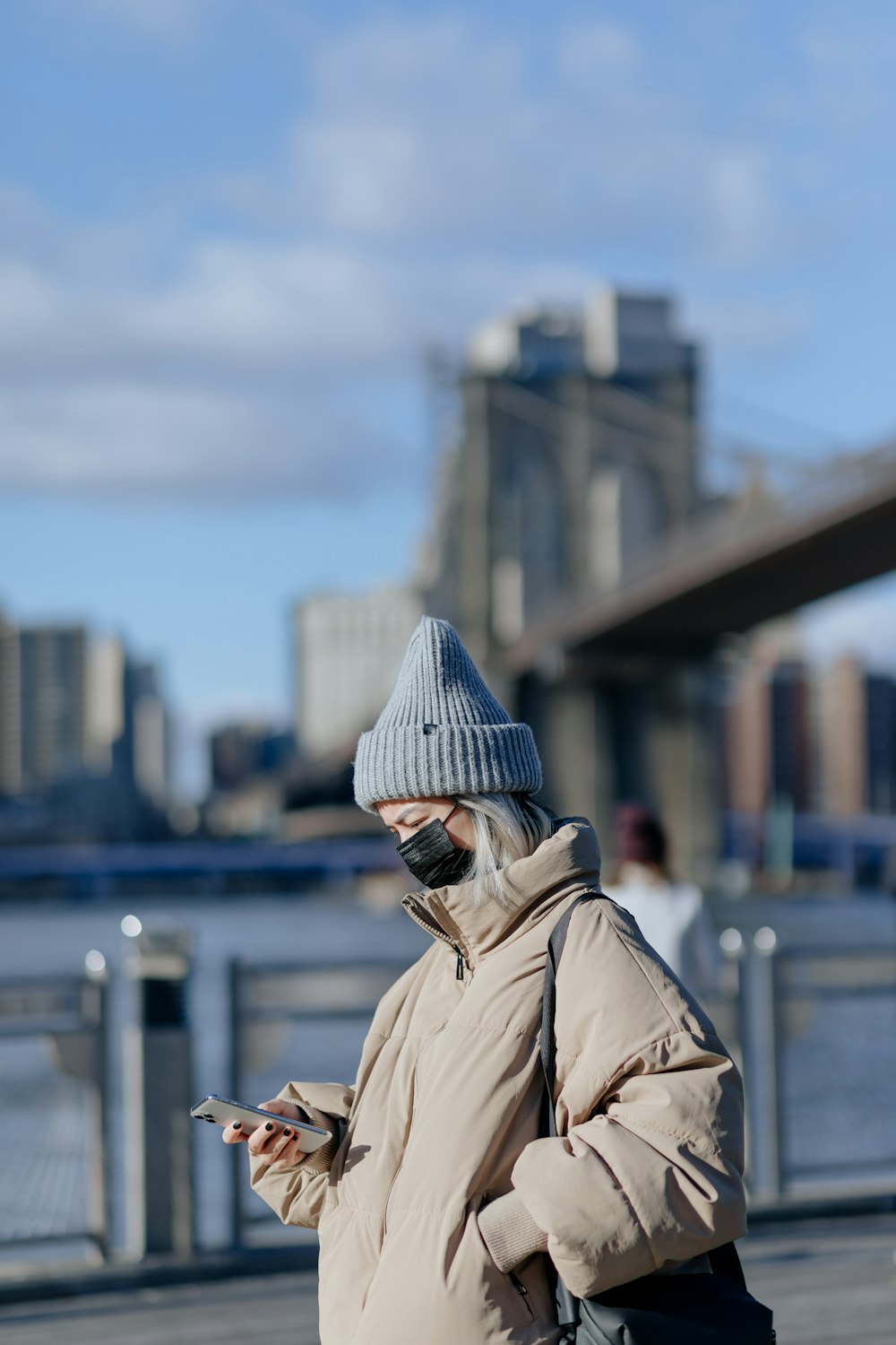 man in brown coat wearing black knit cap and black sunglasses