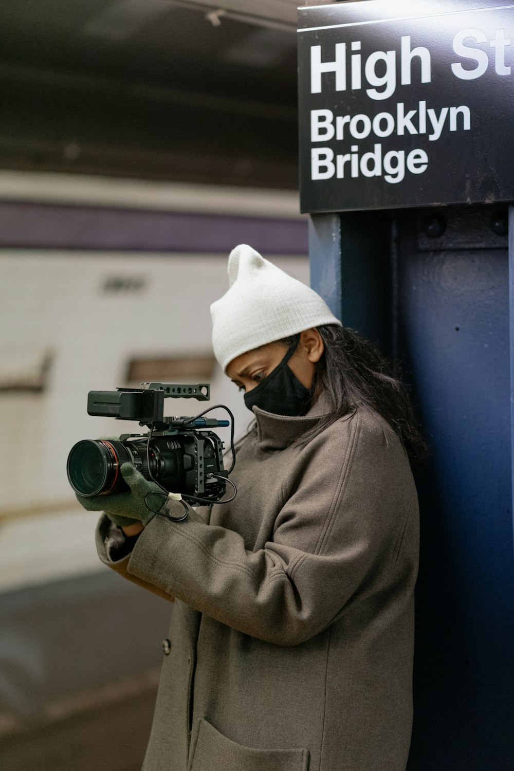 woman in brown jacket holding black dslr camera