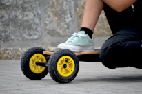 Close-up of a skateboarder’s feet on a board, rolling through an urban street.
