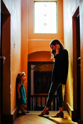 woman in black long sleeve shirt and black pants standing beside brown wooden door