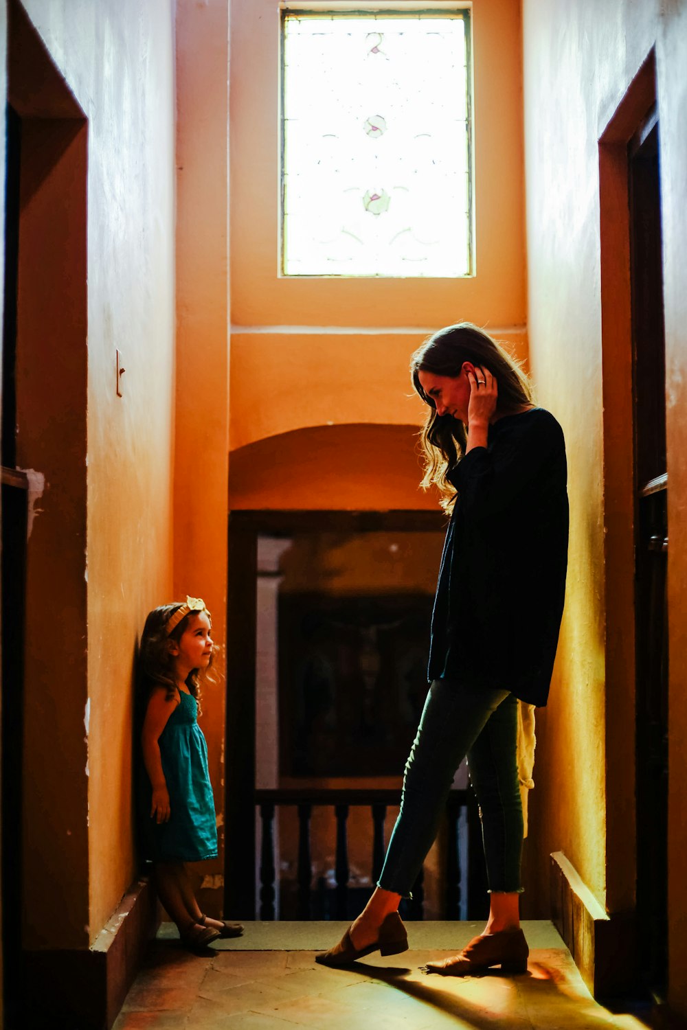 woman in black long sleeve shirt and black pants standing beside brown wooden door