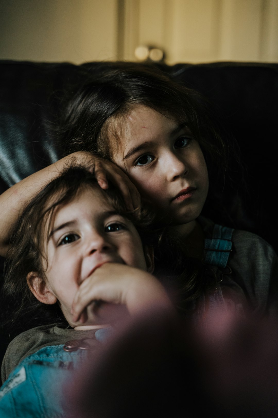 girl in blue shirt lying on black textile