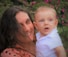 woman in orange and black shirt carrying baby in white shirt