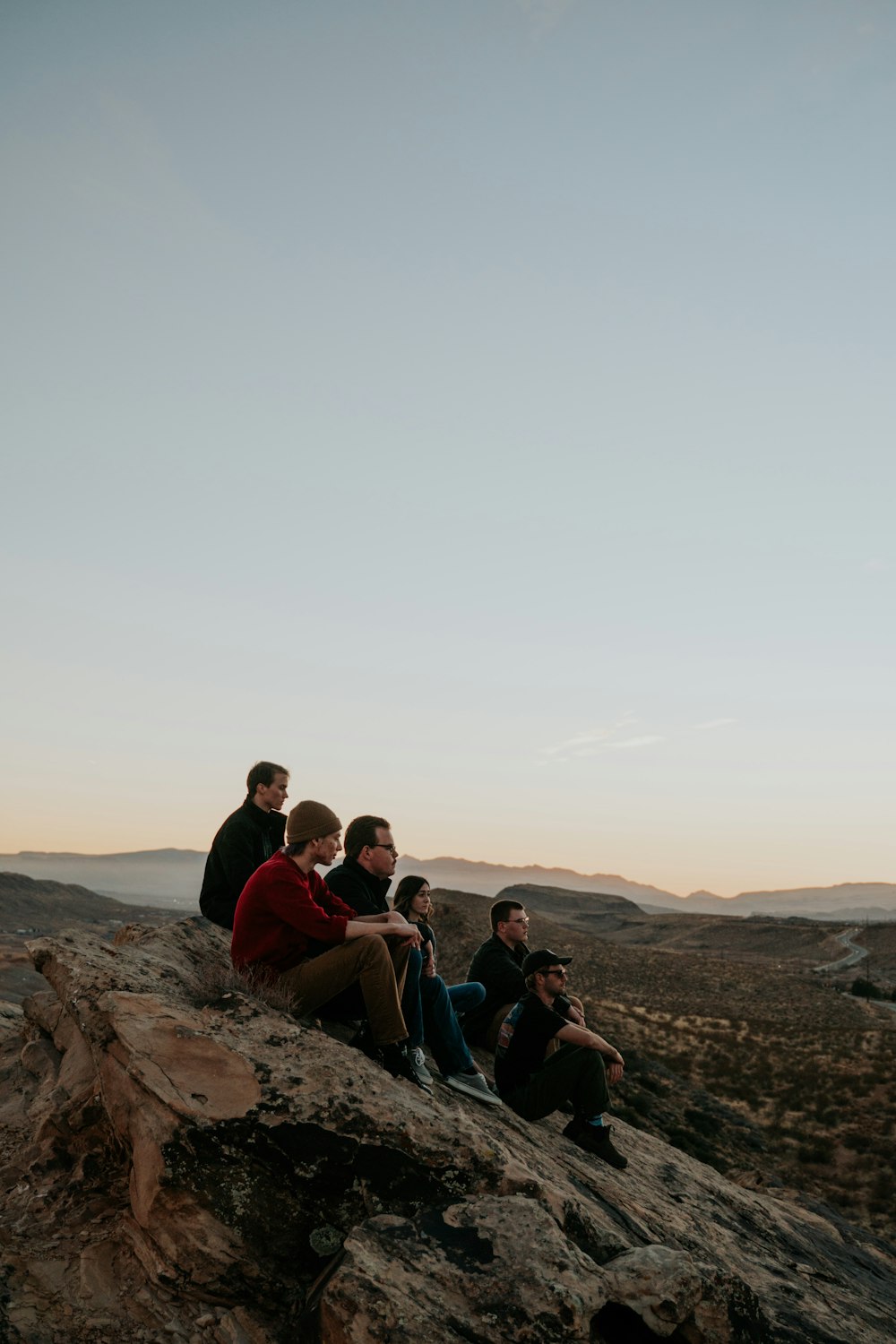 people sitting on brown rock formation during daytime