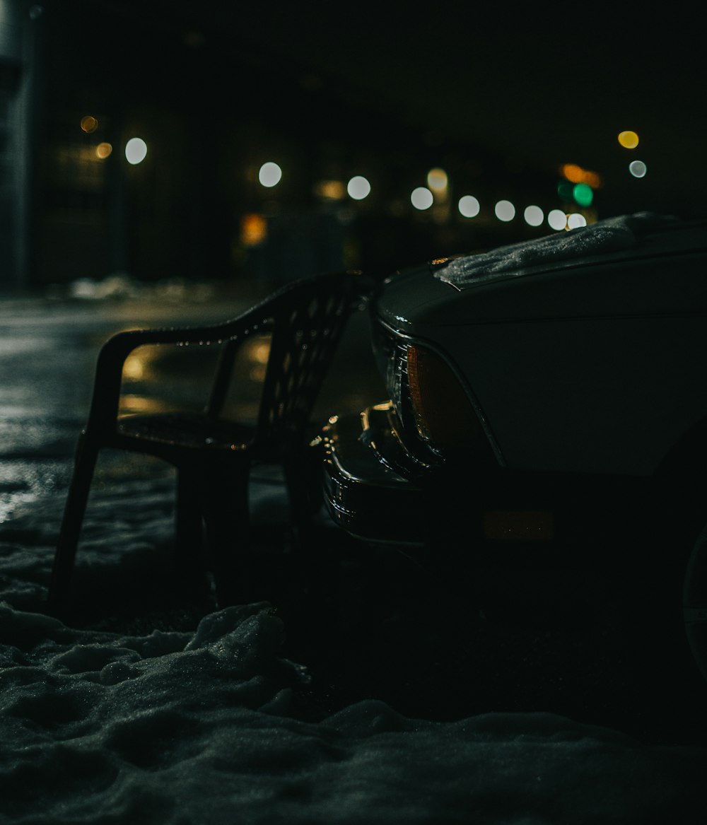 Banco de metal negro en suelo cubierto de nieve durante la noche