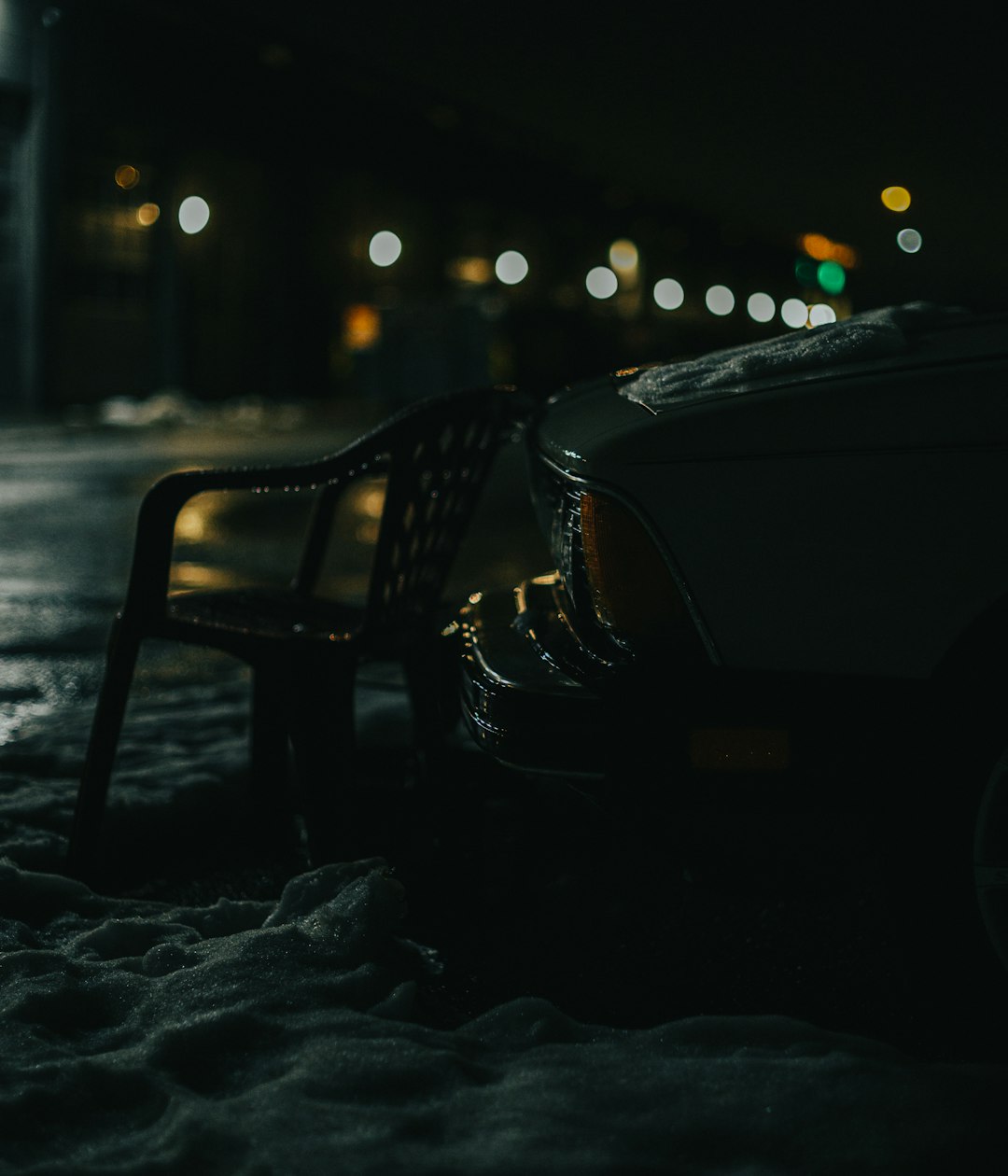 black metal bench on snow covered ground during night time