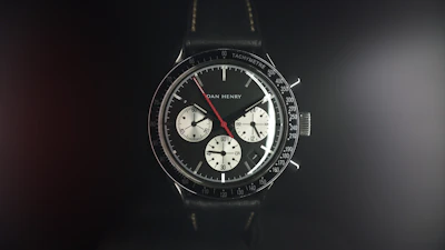 A vibrant red dial watch with a polished stainless steel bracelet shining under soft light.