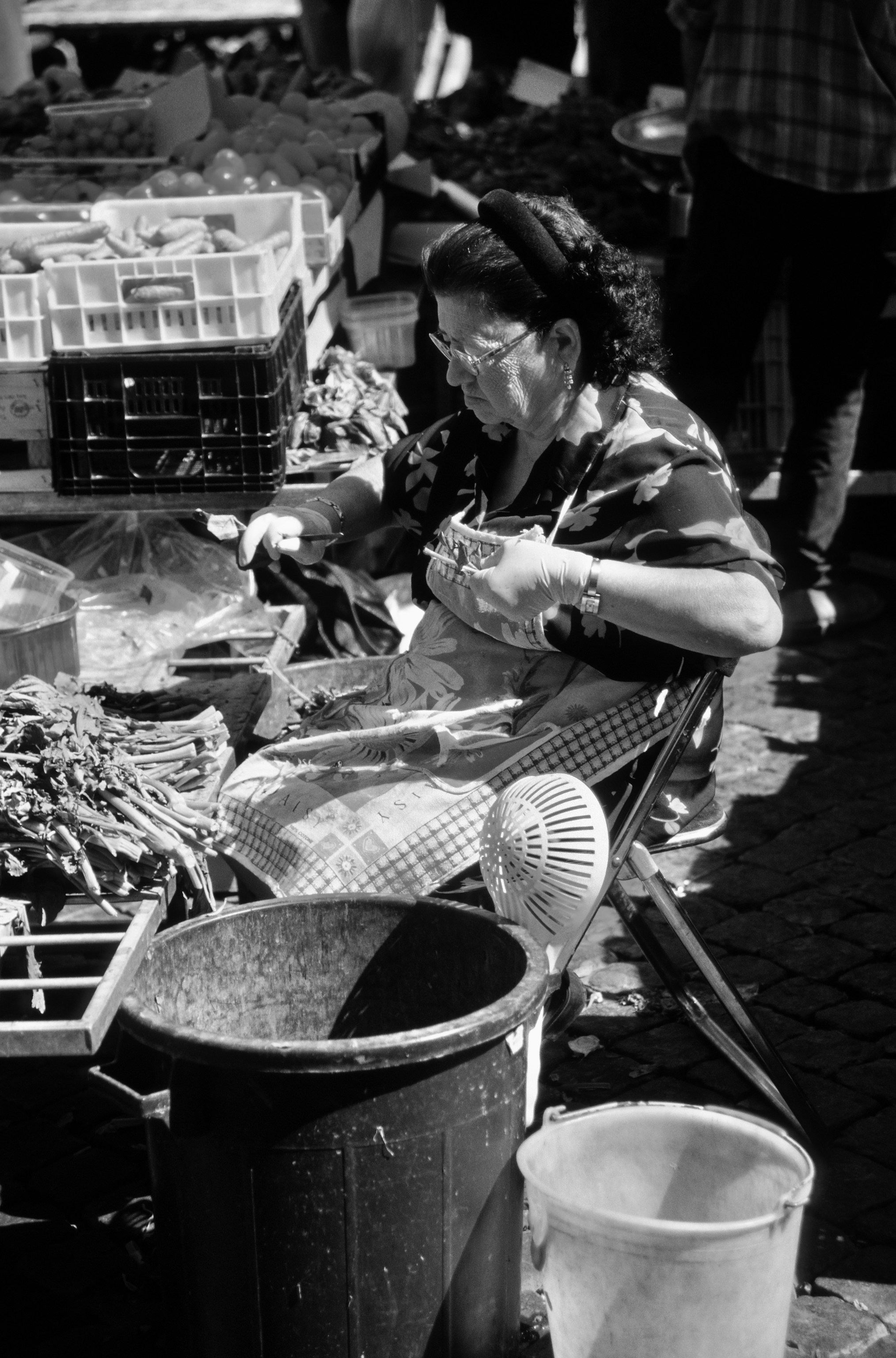 Foto in scala di grigi di donna in camicia bianca e pantaloni neri seduta sulla sedia