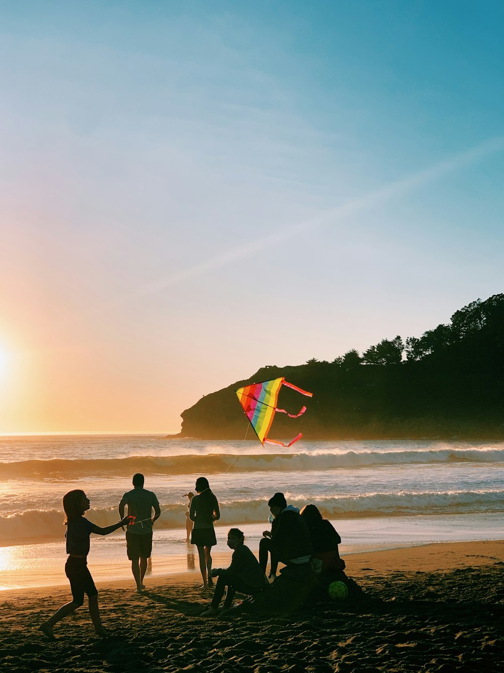 personnes sur la plage au coucher du soleil