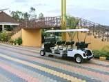 Modern black golf cart with tinted windows parked beside a clubhouse.