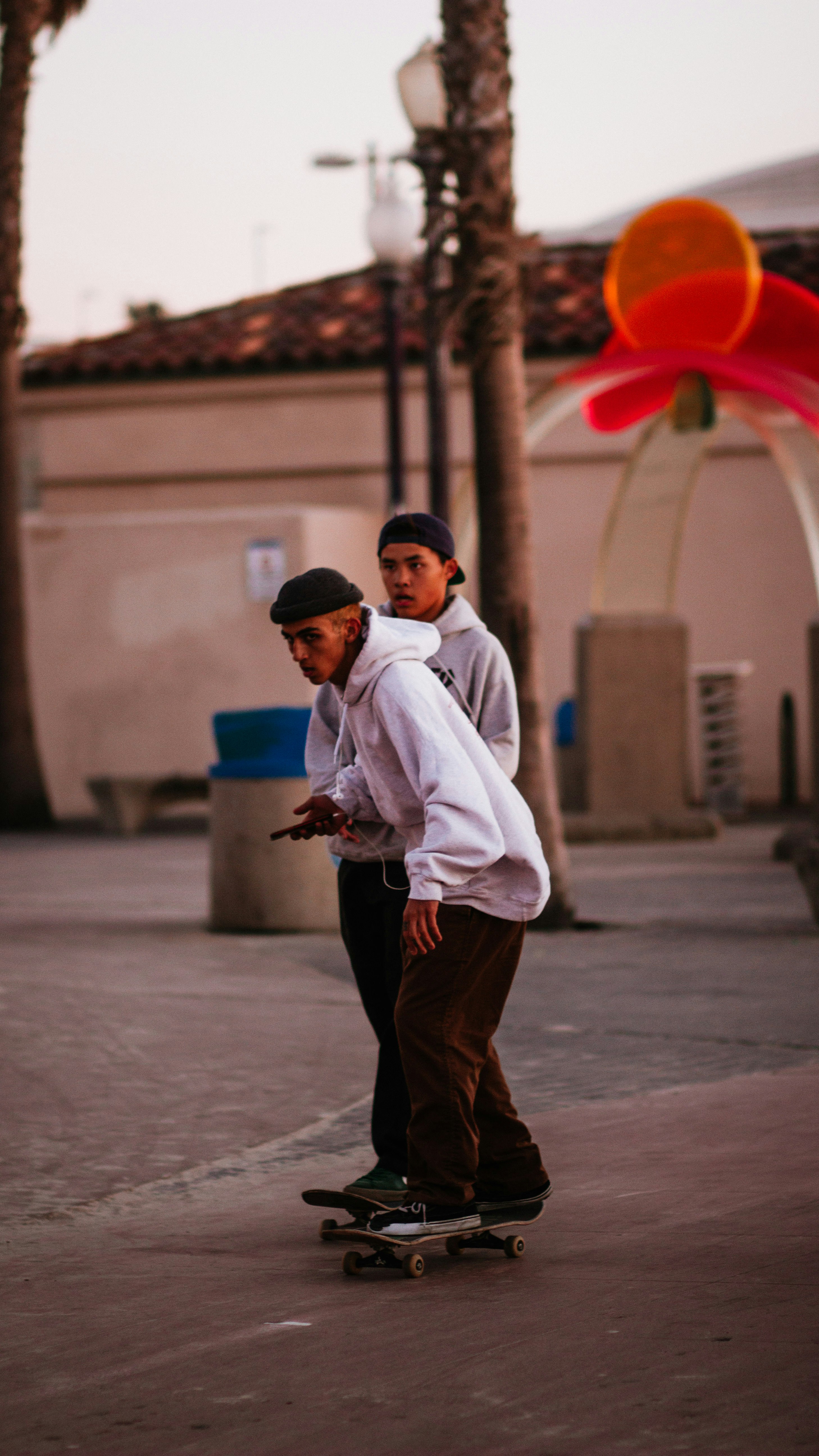 man in white dress shirt and brown pants standing on gray concrete floor during daytime