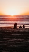 A group of travelers enjoying a beach sunset.