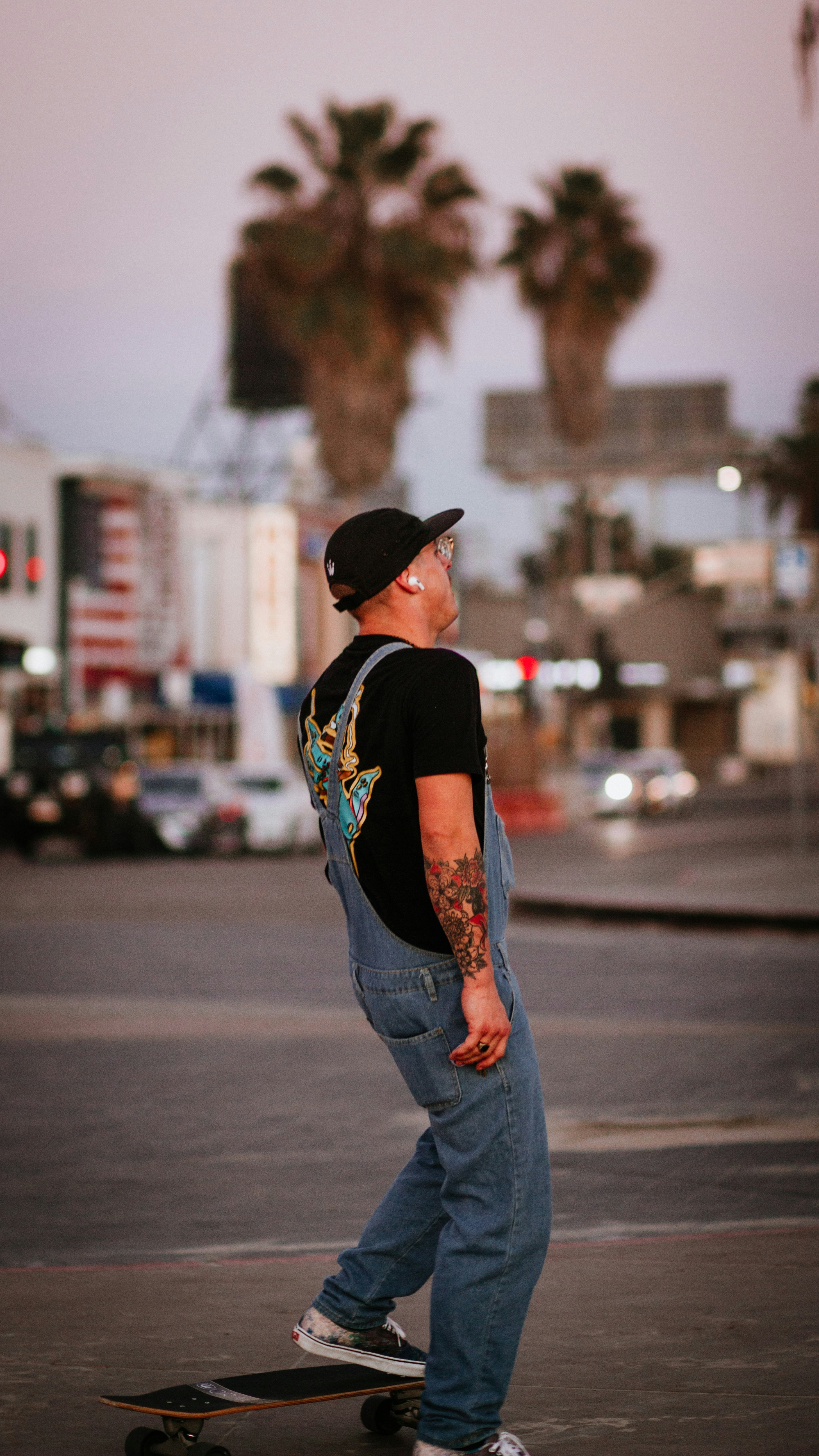 man in black and white crew neck t-shirt and blue denim jeans standing on road