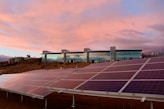 solar panels on brown field under white clouds during daytime