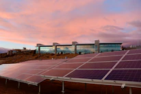 A solar-powered building with panels integrated into the facade during sunset